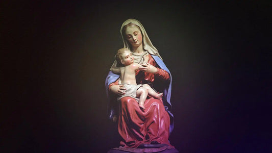 virgin mary holding jesus statue in dark background