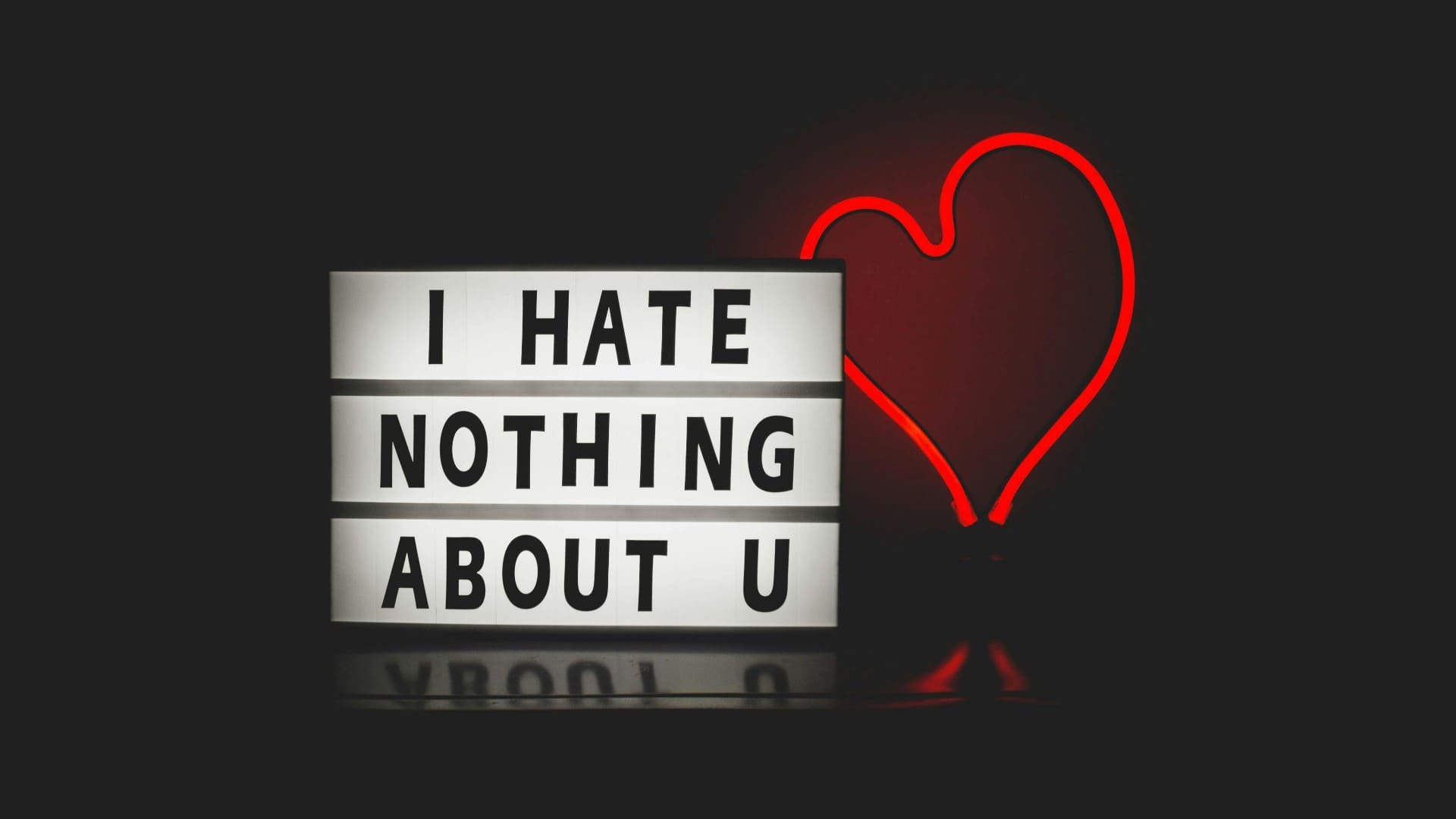 "I hate nothing about you" slogan and red heart shaped background with neon light effects